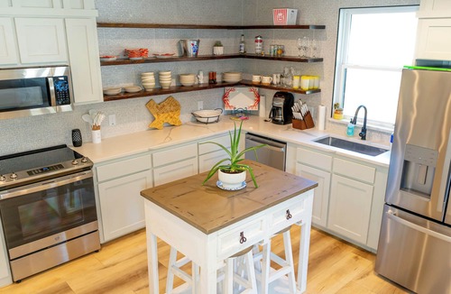 Saint Jo House | Stylish 3BR Southwest home for 6 near wineries, dining, and breweries. Features a chef’s kitchen, spacious living area, washer/dryer, and a private backyard with a unique guitar-shaped fire pit.